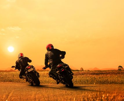 couples friend motorcycle rider biking on asphalt highway against beautiful sun set sky use for people and man leisure activities in motorsport and traveling theme