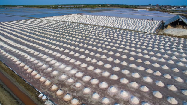 aerial view Heap of sea salt in original salt produce farm make from natural ocean salty water preparing for last process before sent it to industry consumer