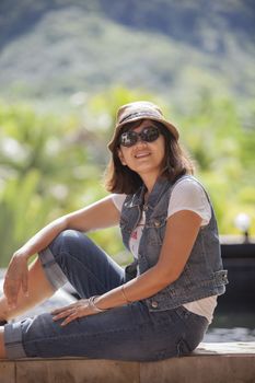 portrait of asian 40s years woman wearing straw hat and sun glasses toothy smiling face with happiness emotion relaxing on vacation