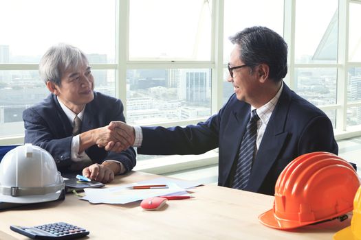 two engineer construction business man shaking hand after project solution meeting successful in office meeting room