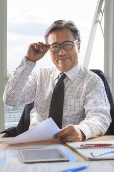 senior business man working on office table with smiling face happiness emotion