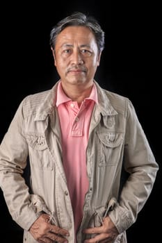 portrait close up smiling happiness face of 59s years old asian man with studio light against black background