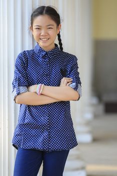portrait of thai 12s years girl wearing blue shirt standing out door with toothy smiling face happiness emotion