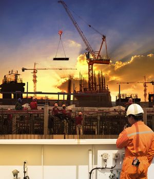 contractor and construction worker working in building construction site