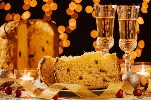 Sliced italian panettone and sparkling wine with decorations