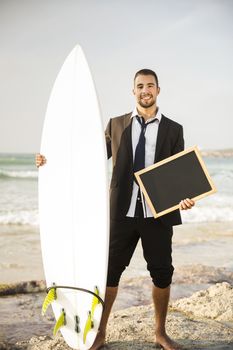 Businessman holding a chalkboard and is surfboard. Concept about a man starting a new life.