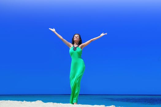 Happy smiling woman enjoy vacation on beach with raised hands