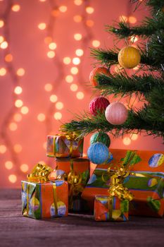 Christmas gifts with blurred lights on background over the planks under the tree