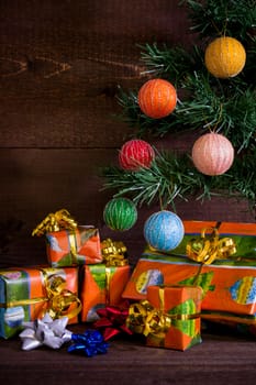 Many Christmas presents under the tree and decorations on plank background