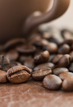 Close up roasted coffee beans and coffee cup