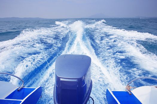 rear view of speed boat running high speed on blue sea water use for traveling to island destination