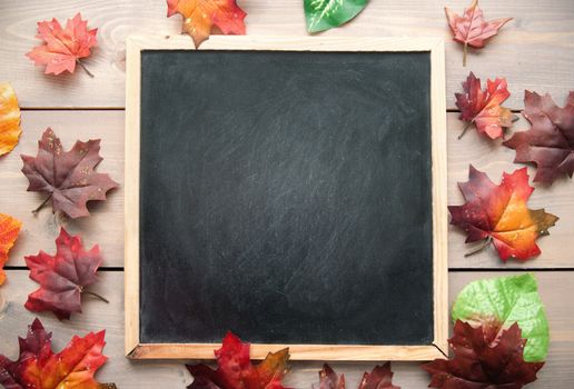 Autumn leaves around a blackboard with space 