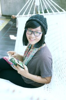 portrait of beautiful asian woman relaxing time reading book on cradle happiness emoton with smiling face