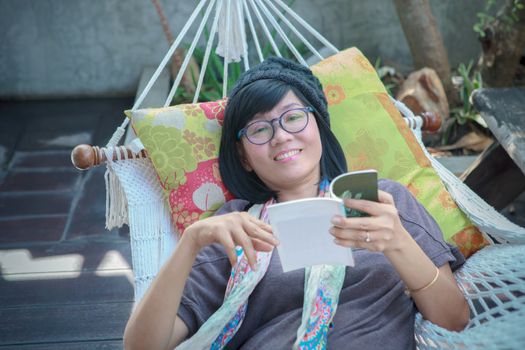 portrait of beautiful asian woman relaxing time reading book on cradle happiness emoton with smiling face