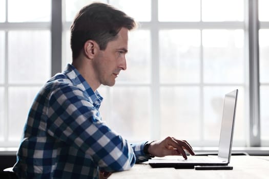 Man working with laptop on wooden table