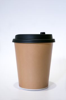 The brown paper cup of hot coffee with black cap.