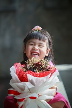 asian girl with dry flower bouquet in hand laughing with happiness emotion
