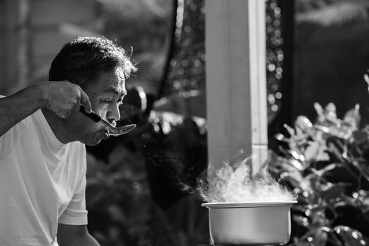 old man cooking morning food meal in hot pot on lpg gas stove