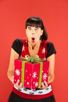 Front view on single woman with happy expression holding large Christmas gift box