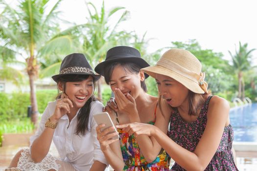 group of woman friend looking to smart phone and laughing with happiness face ,relaxing vacation of people lifestyle