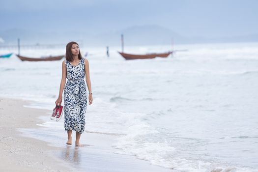single woman walking lonely with sorrow face on sea beach 