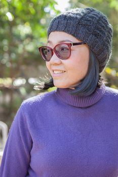 portrait head shot of thai asian woman 40s years old wearing purple winter clothes and wool hood toothy smiling face with happiness emotion