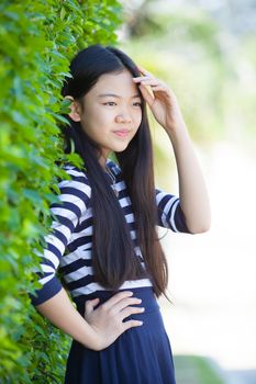 portrait of younger asian teen with happiness emotion and smiling face in green park