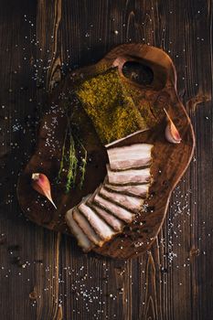 Sliced smoked brisket with garlic, wooden background