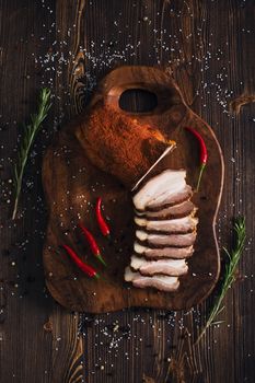 Sliced smoked brisket with pepper, wooden background