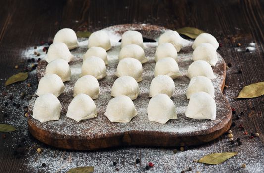 Raw ukrainian meat dumplings on wooden background
