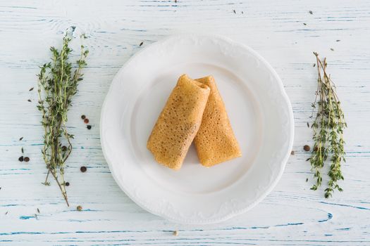 Stuffed pancakes on light wooden background