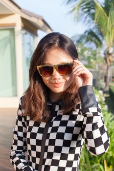 portrait of beautiful chick fashion woman wearing sun glasses against afternoon light with blur background and copy space