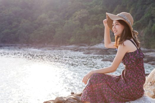 portrait of young beautiful woman wearing long dress and wide straw hat smiling at sea side location use for modern life fashion and people activities on vacation
