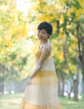 portrait of couples beautiful asian woman standing in blooming flowers park with happiness emotion