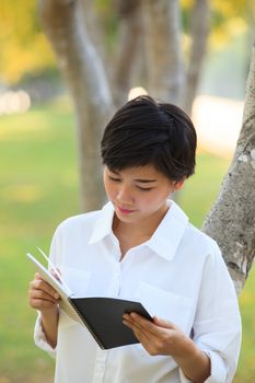 younger woman  reading book in park