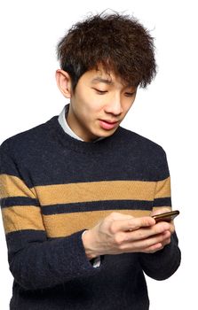 Young man using mobile phone texting on white background