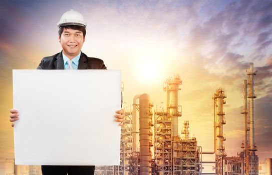 engineering man with white empty white broad standing in front of oil refinery industry estate use for industrial theme