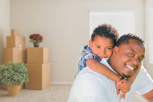 Happy Mixed Race African American Father and Son In Room with Packed Moving Boxes.