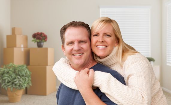 Happy Young Couple in Empty Room with Packed Boxes and Plants.