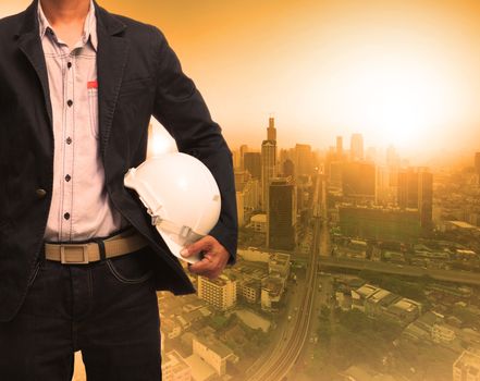 engineering man and sun light behind urban construction background use for land development theme