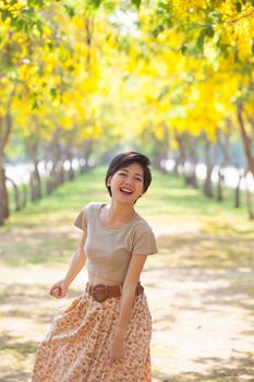 portrait of couples beautiful asian woman standing in blooming flowers park with happiness emotion