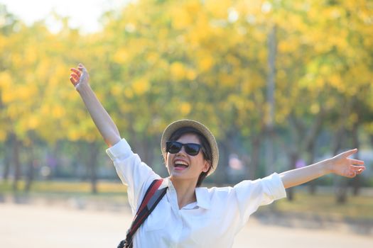 young beautiful woman wearing white shirts ,straw hat and sun glasses rising hand victory shape and toothy smiling use for modern and people lifestyle feeling free 