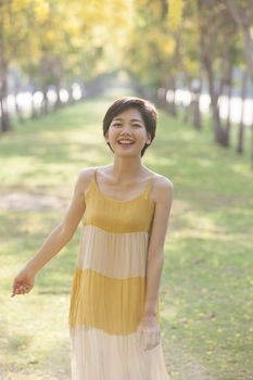 portrait of couples beautiful asian woman standing in blooming flowers park with happiness emotion
