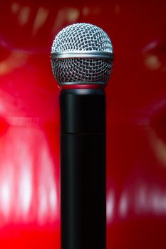 close up texture of microphone in music hall against red luxury background 