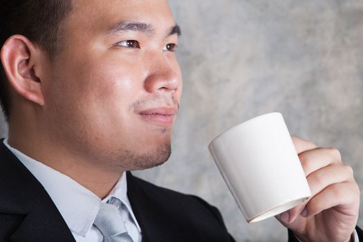 close up face of business man and ceramic coffee cup in hand with happiness emotion in eyes  