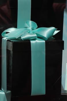 Black gift box with a blue satin bow