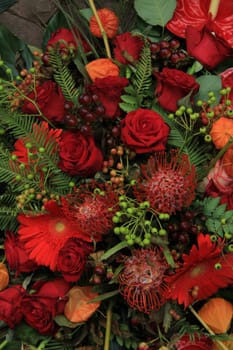 Red roses in a mix flower wedding arrangement in red