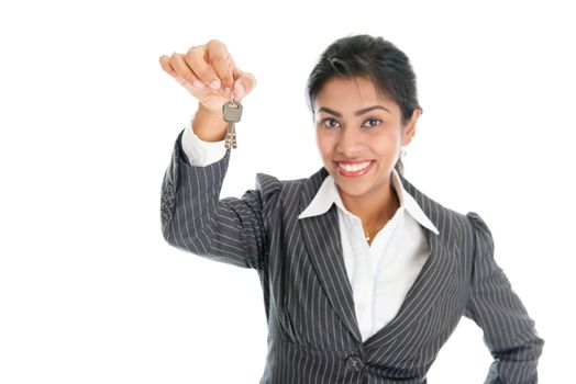 Realtor showing house key and smiling, isolated on white background.