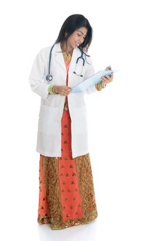 Portrait of full body Indian female doctor with medical test report, standing isolated on white background.