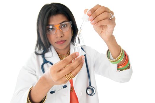 An Indian female medical doctor looking at a test liquid in a laboratory.